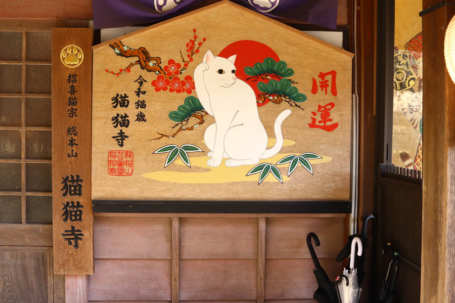 猫猫寺の入り口の巨大な絵馬と看板
